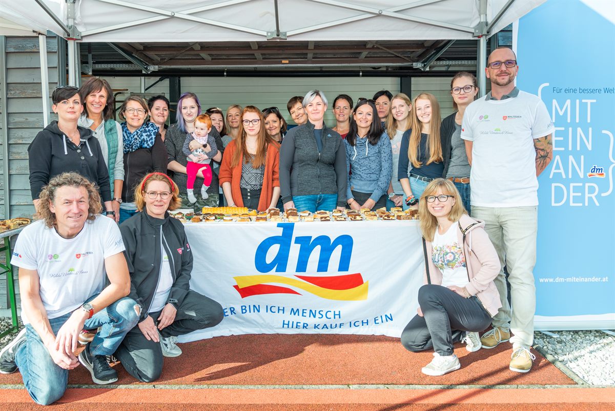 Viele helfende Hände von dm Mitarbeitern teilten Kuchen, Snacks und Getränke an die Teilnehmer des Kinderhilfelaufs Amstetten aus.