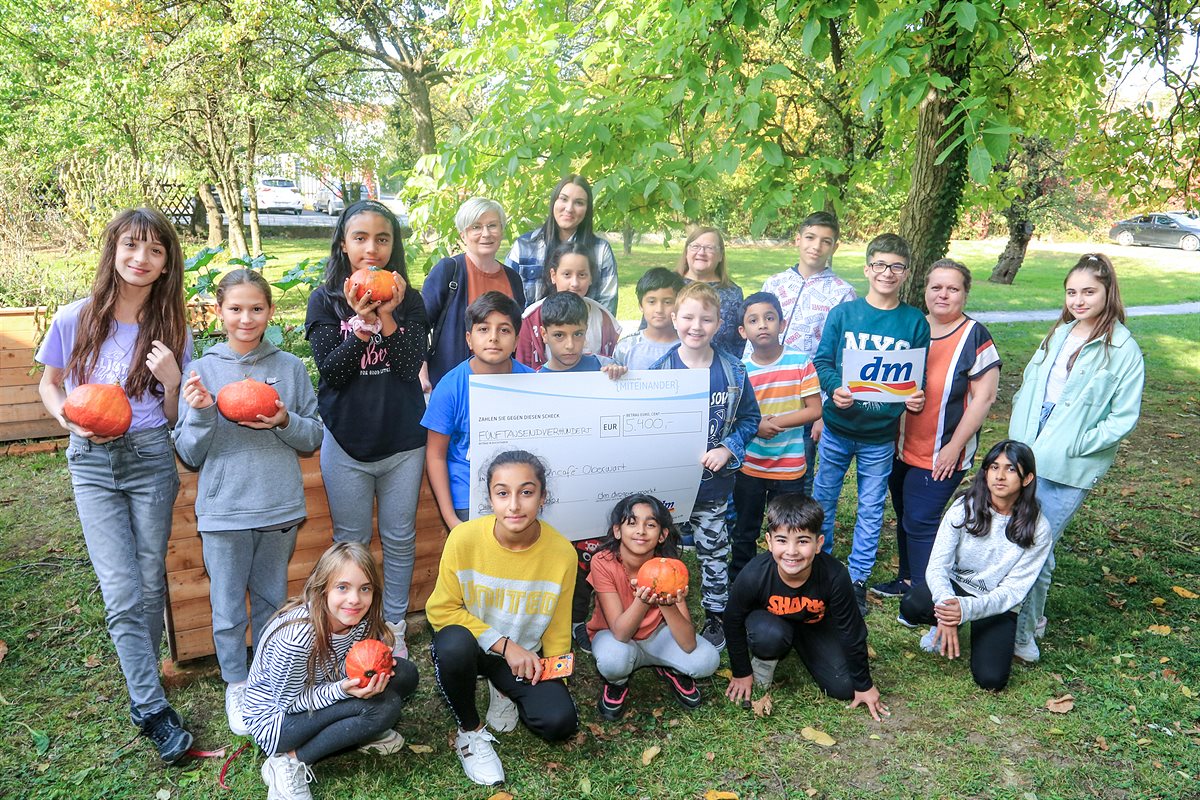 Scheckübergabe in Oberwart (v.l.) mit dm Mitarbeiterin Monika Miklos, dm Filialleitung Selina Grandits, freiwillige Helferin Elisabeth, Standortleiterin Barbara Lechner und den Kindern des Lerncafés